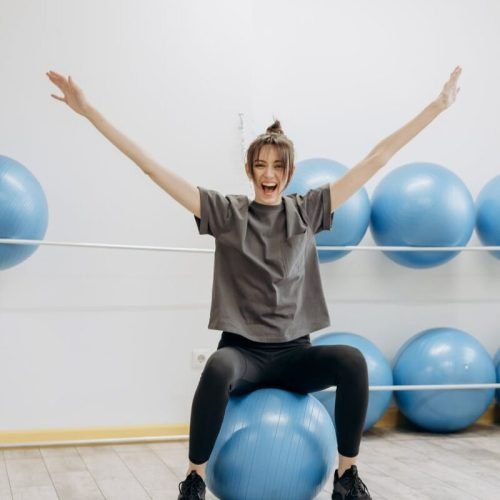 Photo by Mikhail Nilov on <a href="https://www.pexels.com/photo/woman-sitting-on-a-yoga-ball-with-arms-raised-6740745/" rel="nofollow">Pexels.com</a>