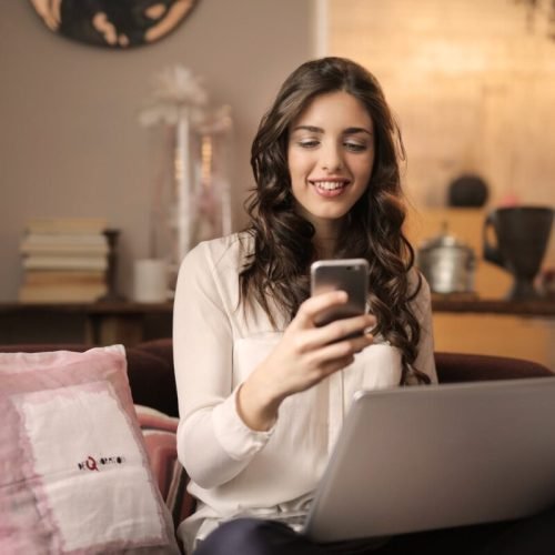 Photo by Andrea Piacquadio on <a href="https://www.pexels.com/photo/woman-sitting-on-sofa-while-looking-at-phone-with-laptop-on-lap-920382/" rel="nofollow">Pexels.com</a>